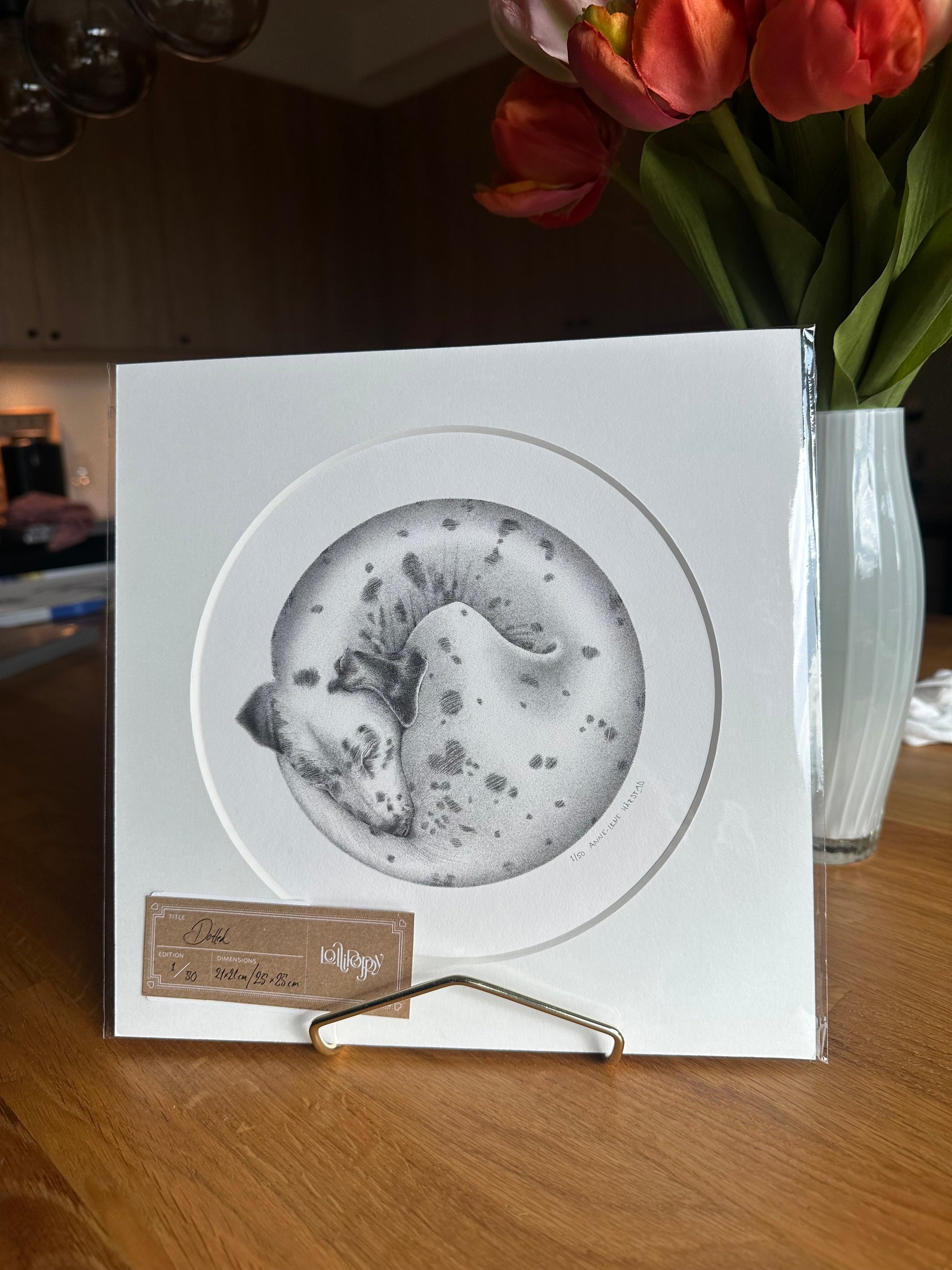 A square white art print or card featuring a circular black-and-white illustration of a dalmatian